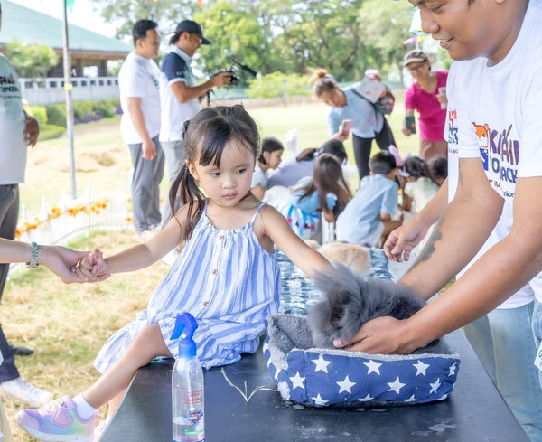A child petting a bunny with help from our staff