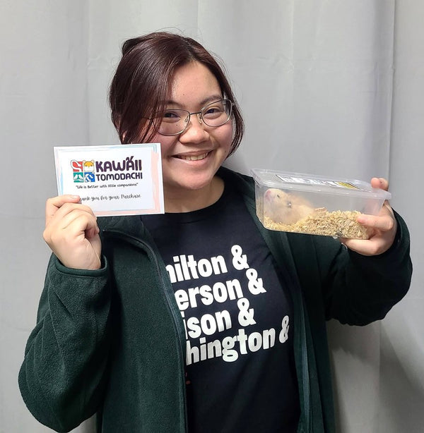 A customer holding her new hamster and our thank-you card